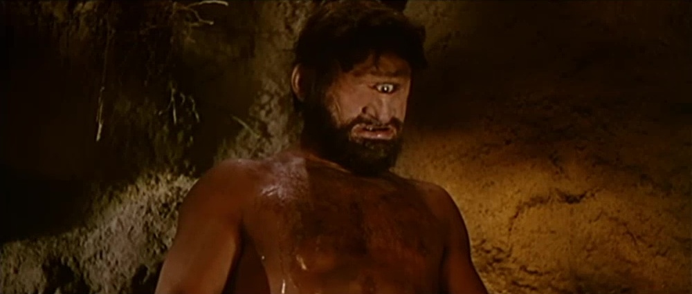 Sos Orcos e sos Gigantes Nel tempo de sos de jàna (abitatori delle domus de jàna) c’erano anche sos Orcos che avevano un occhio solo in mezzo alla fronte e mangiavano carne umana. Erano molto potenti, abitavano nei nuraghi e avevano zanne di cinghiale, ed erano molto birbantes. I gigantes invece erano belli e potenti, mannos de istatura, e gli Orcos li temevano. Gli Orcos tormentavano invece i più deboli che erano gli uomini come noi. A questo proposito sos Mannos raccontavano: C’era un uomo bruttissimo e peloso, ma con due occhi come noi, che era chiamato Tinzòsu. Uno degli Orcos va nell’ovile di Tinzosu e gli dice: “Ti voglio mangiare”. “Ite bisonzu b’hat de manicare a mie? – risponde Tinzosu – B’happo unu bellu porcu. Picca ca l’occhidimus e no nchelu manicamus”. Tinzosu mette la carne negli spiedi, poi ne afferra uno arroventato e lo infigge nell’occhio dell’Orcu. L’Orcu accecato si lancia intorno all’ovile per uscire e non può. E così Tinzosu si salva. (Cercare ancora il racconto o farlo ripetere)